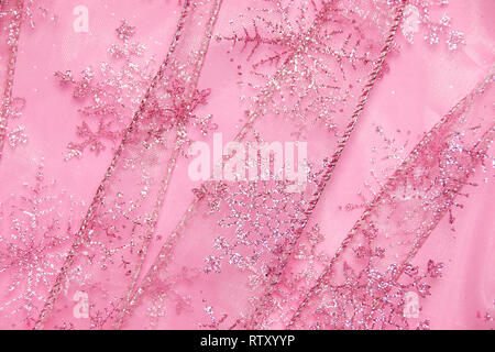 Un abstract texture di sfondo close up dettaglio in un Natale nastro rosa glitter con i fiocchi di neve Foto Stock