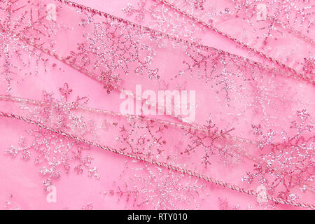 Un abstract texture di sfondo close up dettaglio in un Natale nastro rosa glitter con i fiocchi di neve Foto Stock