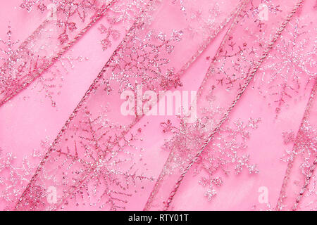 Un abstract texture di sfondo close up dettaglio in un Natale nastro rosa glitter con i fiocchi di neve Foto Stock