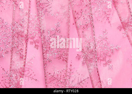 Un abstract texture di sfondo close up dettaglio in un Natale nastro rosa glitter con i fiocchi di neve Foto Stock