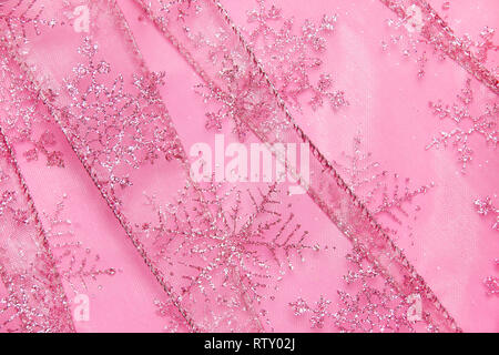 Un abstract texture di sfondo close up dettaglio in un Natale nastro rosa glitter con i fiocchi di neve Foto Stock