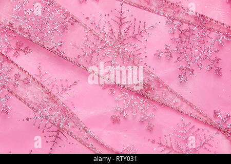 Un abstract texture di sfondo close up dettaglio in un Natale nastro rosa glitter con i fiocchi di neve Foto Stock