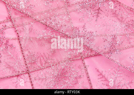 Un abstract texture di sfondo close up dettaglio in un Natale nastro rosa glitter con i fiocchi di neve Foto Stock