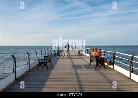 Turisti che si godono il molo cambs, North Yorkshire, Inghilterra. Foto Stock