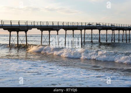 Onde che si infrangono sotto il molo cambs, North Yorkshire, Inghilterra. Foto Stock