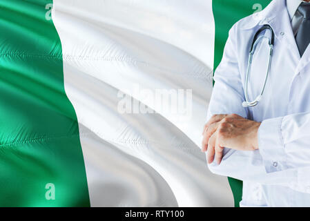Medico nigeriano in piedi con uno stetoscopio sulla Nigeria bandiera dello sfondo. Sistema sanitario nazionale concetto, tema medico. Foto Stock