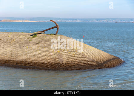 Appledore, North Devon, Inghilterra, Regno Unito. Febbraio 2019. L'uomo ha fatto frangionde con un vecchio elemento di ancoraggio sulla Appledore Harbour Foto Stock