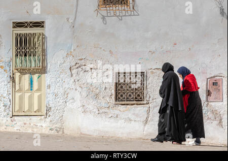 Due woment musulmani camminare tra le rovine dell'antico quartiere ebraico (mellah) in Sefrou, Marocco Foto Stock