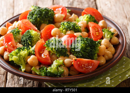 Vegetariano organico Insalata di broccoli, ceci e pomodori con olio d'oliva closeup su una piastra sul tavolo orizzontale. Foto Stock