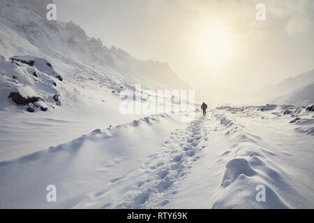 Tourist sulla strada innevata delle bellissime montagne in inverno Foto Stock