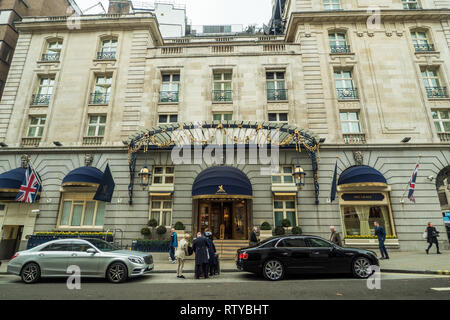 Gli ospiti di essere aiutato con i loro bagagli fuori "The Ritz London' hotel nella zona di Mayfair di Londra. Foto Stock
