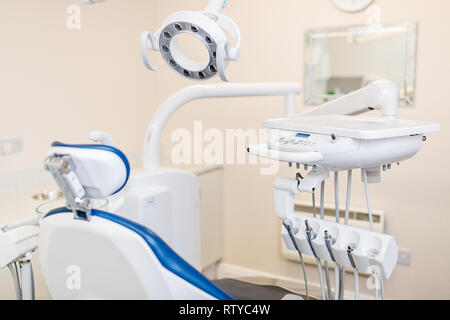 Close up della moderna poltrona odontoiatrica e apparecchiature con lampada di overhead in chirurgia dentale Foto Stock