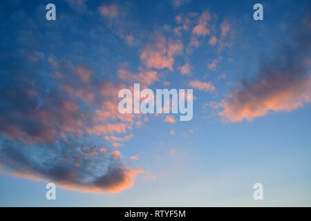 Un'immagine orizzontale di Nuvole rosa che riflette il sole di setting in rural Alberta Canada Foto Stock