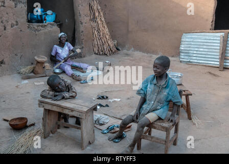 Una foto che ritraggono la vita quotidiana di una famiglia del Ghana. Ci sono madre e bambini sulla foto. Foto Stock