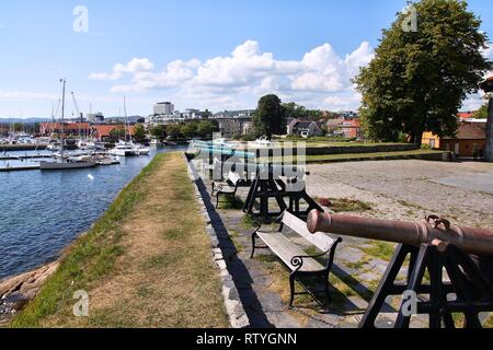 Kristiansand, Norvegia. Capitale della Contea di Vest-Agder. I cannoni al costiero fort. Marina in background. Foto Stock