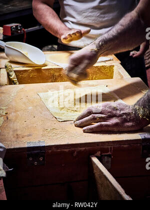 Due cuochi rendendo tortillas su una tavola di legno tavolo rustico. Foto Stock