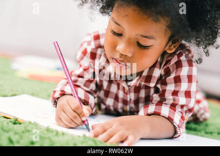 Carino giovane americano africano ragazza di capretto il disegno o la pittura con la matita colorata. Kindergarten bambini educazione, torna a scuola o a bambini in età prescolare Foto Stock