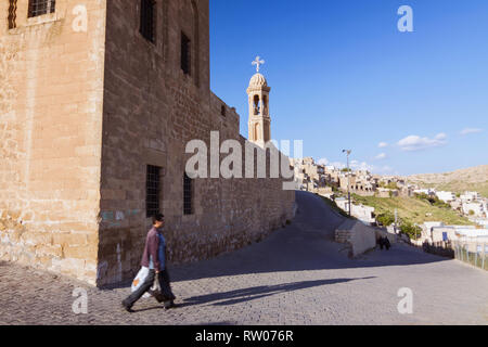 Mardin, Anatolia sud-orientale, la Turchia : un uomo cammina passato una lingua Siriaca ortodossa nella città vecchia di Mardin. Foto Stock