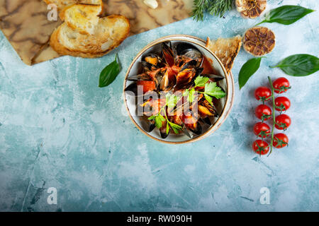 Le cozze nella piastra servita con pomodori, toast e limone Foto Stock