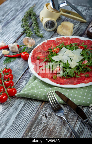 Close-up carpaccio di carne con rucola e scaglie di parmigiano Foto Stock