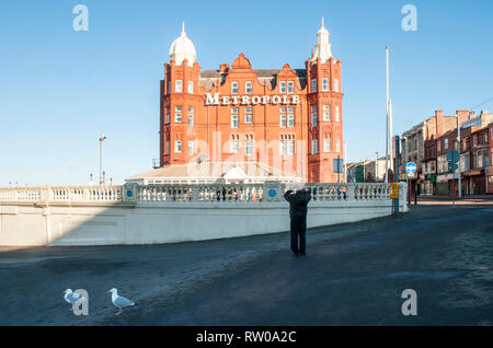 Metropole Hotel sul lungomare della località balneare di Blackpool Lancashire Inghilterra con uomo prendendo foto e due locali gabbiani in primo piano Foto Stock