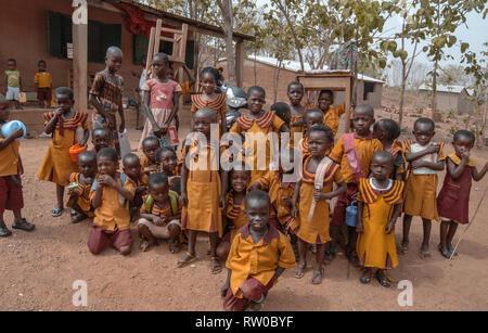 Una foto di gruppo della locale scuola di ghanesi bambini indossare giallo uniformi scolastiche a Kongo Village, Ghana Foto Stock