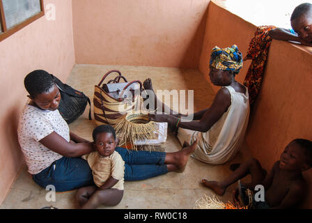Una foto di una donna del Ghana con un bambino e sua madre rendendo famoso mercato Bolgatanga ceste di erba elefante (veta vera) Foto Stock