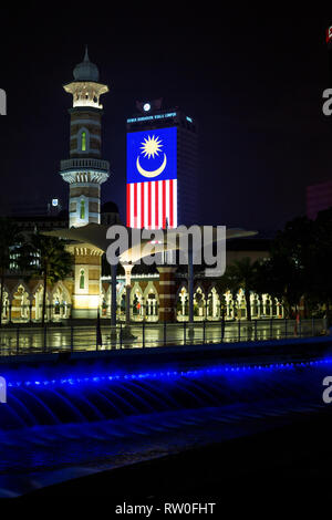 Masjid Jamek (Jamek Moschea) di notte, bandiera malese in background. Kuala Lumpur, Malesia. Foto Stock