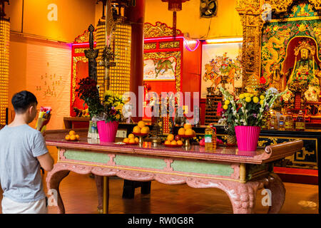 Giovane uomo che offre la preghiera di Guan Di (Kuan Ti), il dio della guerra, il Tempio Taoista, Chinatown, Kuala Lumpur, Malesia. Foto Stock