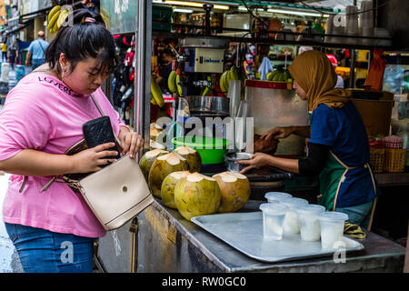 Il cliente ad acqua di cocco Stand, Kuala Lumpur, Malesia. Foto Stock