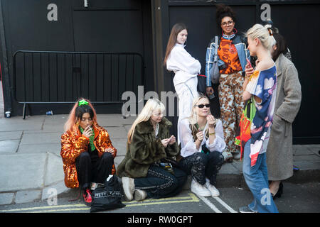 Londra - 15 febbraio 2019: Elegante partecipanti al di fuori di raccolta 180 del filamento per la London Fashion Week. Ragazze seduta di fumo sul marciapiede Foto Stock