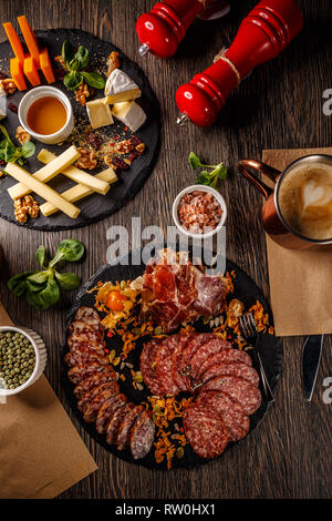 Lay piatto di salumi e formaggi della piastra sulla tavola di legno Foto Stock