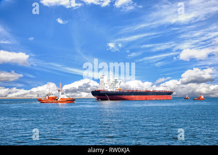 Nave cisterna con la scorta rimorchiatori lasciando port. Foto Stock