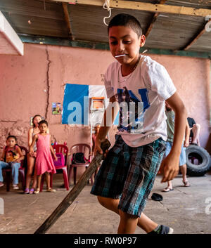 Giovane ragazzo latino swinging a pinata a Guatemala festa di compleanno Foto Stock