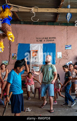 Giovane ragazzo latino swinging a pinata a Guatemala festa di compleanno Foto Stock