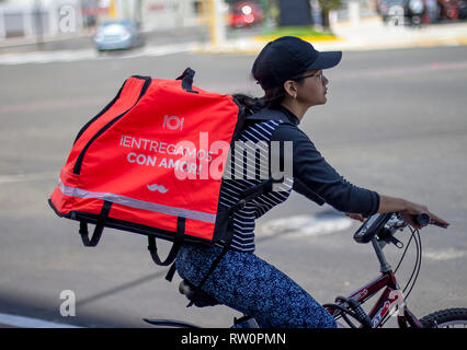 Lima in Perù - 3 Marzo 2019: Donna Bicicletta Equitazione lavorando per alimentare Rappi servizio di consegna. Condivisione di economia collaborativa concetto in Sud America. Foto Stock