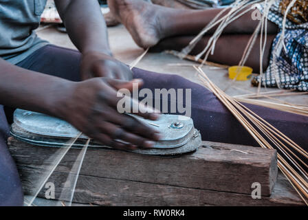 Un primo piano delle mani di una donna di tessitura del famoso mercato Bolga cestello usando le cannucce di erba elefante (vera veta). Foto Stock