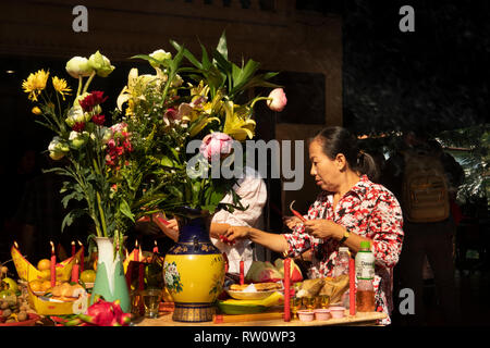 Cambogia, Phnom Penh, centro città, Wat Phnom, Neak Ta Preah Chao Santuario, adoratori accendendo candele offerte anongst Foto Stock