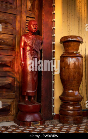 Cambogia, Phnom Penh, centro città, Wat Ounalom, statua lignea del venerato Patriarca fuori porta del tempio Foto Stock