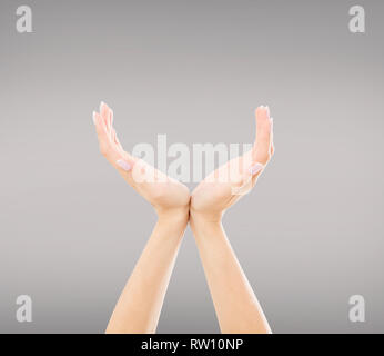 Mani qualcosa di invisibile, isolata su uno sfondo grigio Foto Stock