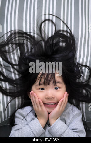 Giovane ragazza si sveglia la mattina sorridente Foto Stock