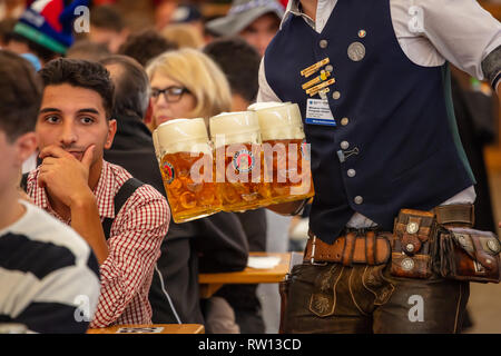 Il 7 ottobre 2018. Monaco di Baviera, Germania, Oktoberfest, cameriere in costume tirolese holding birre, tenda di fondo interna Foto Stock