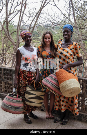 Una bella foto di tre felice e sorridente le donne indossano tradizionali abiti del Ghana in posa per la fotocamera con belle intrecciato cesti Bolga Foto Stock