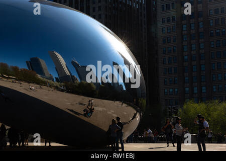 Il fagiolo in Millennium Park che riflette un cielo blu, gli edifici e le persone - Chicago, IL Foto Stock