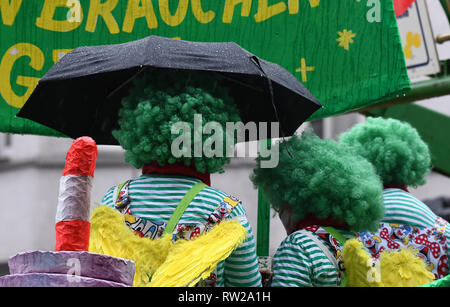 04 marzo 2019, della Renania settentrionale-Vestfalia, Düsseldorf: Carnivalists sostare sotto un ombrello durante il Martedì Grasso lunedì processione. Con la rosa lunedì processioni, Renania street carnival raggiunge il suo culmine. Foto: Ina Fassbender/dpa Foto Stock