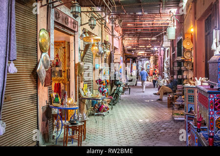 Delle bancarelle che vendono una linea merci stretto sentiero in coperta souk, Marrekech, Marocco Foto Stock