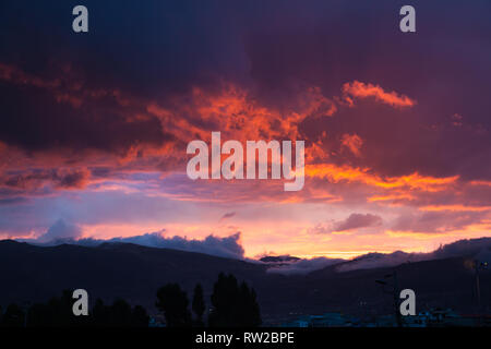 Drammatico tramonto andino composta di nuvole in rosso, blu e toni di colore giallo Foto Stock