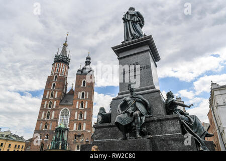 Basso angolo vista di Adam Mickiewicz monumento con l'esterno della chiesa della Madonna Assunta in Cielo (St. Mary's Basilica) in background, Kraków-w, Le Foto Stock