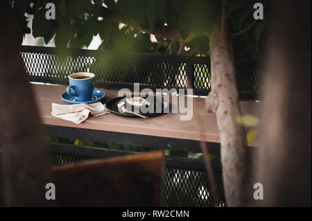 Scena astratta di coffee break pasto insieme comprendente il caffè nero e brownie cheese cake su legno outdoor bar. Fine settimana attività mattutina con buona emotio Foto Stock