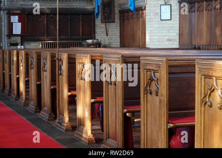 File di banchi vuoti in una chiesa Foto Stock